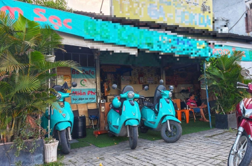 Xe máy điện đang sạc tại quán cà phê trên đường Nguyễn Văn Linh