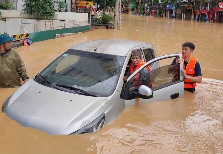 Người dân hỗ trợ đẩy xe thoát khỏi vùng ngập
