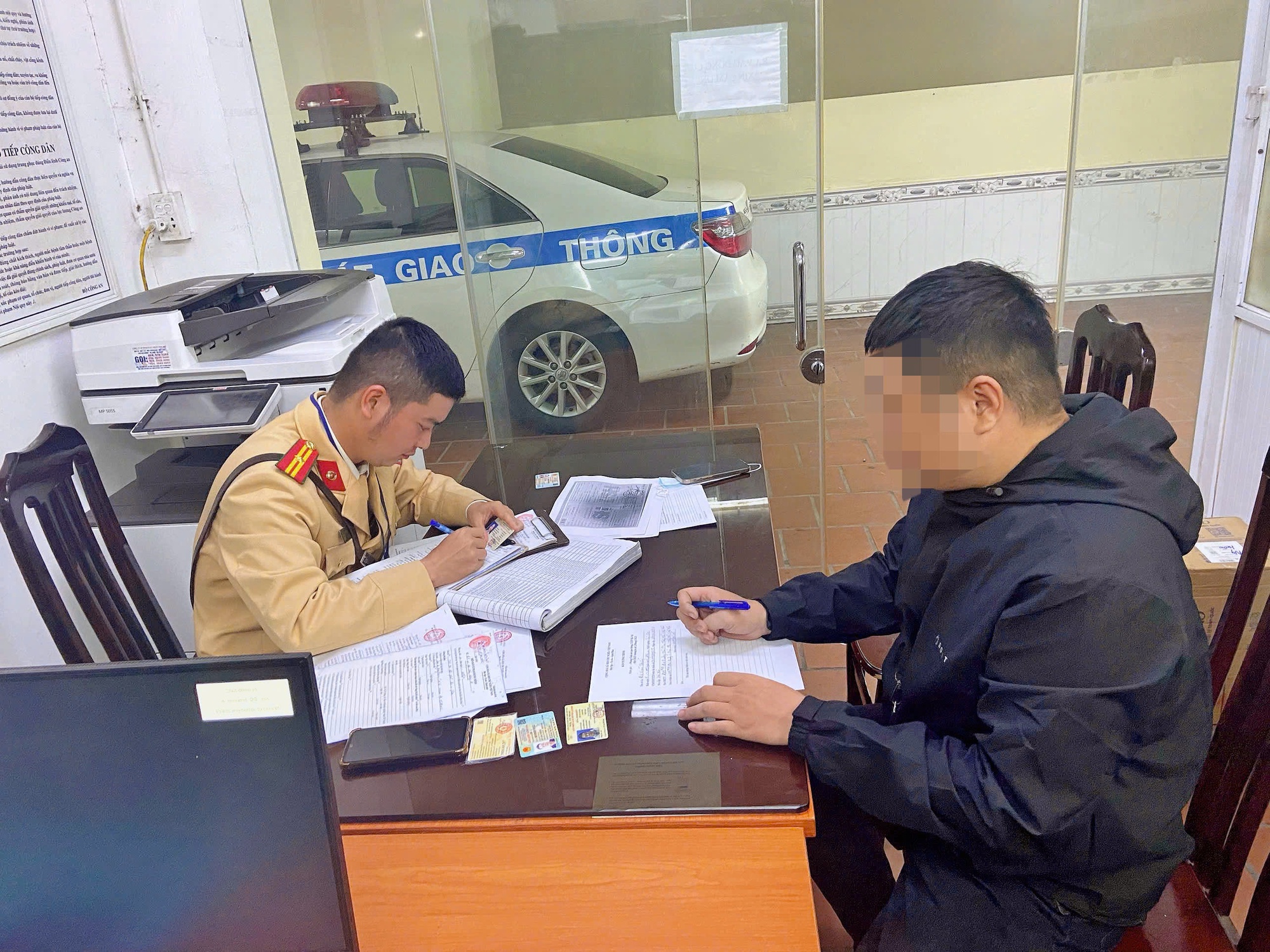 Trừ 4 điểm trên GPLX đối với thanh niên vừa điều khiển xe vừa sử dụng điện thoại- Ảnh 2. Người điều khiển xe mô tô làm việc tại cơ quan công an.