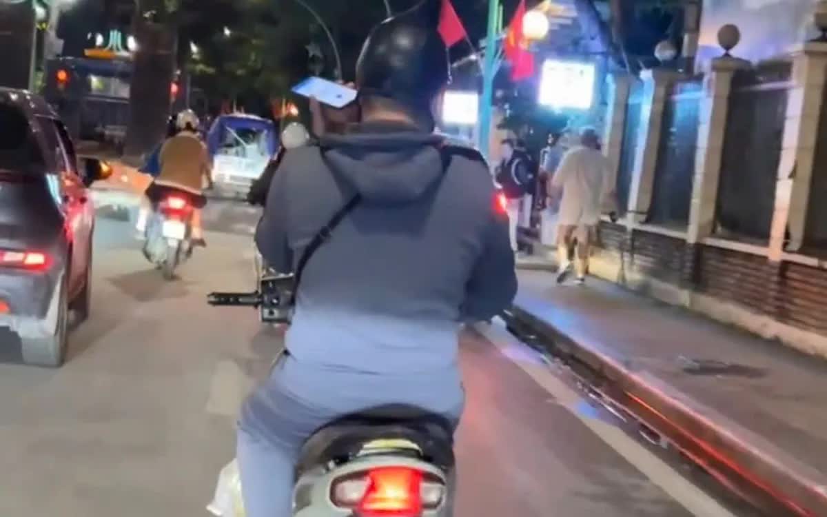 Trừ 4 điểm trên GPLX đối với thanh niên vừa điều khiển xe vừa sử dụng điện thoại- Ảnh 1. Hình ảnh thanh niên sử dụng điện thoại di động khi đang điều khiển xe được người dân ghi hình.